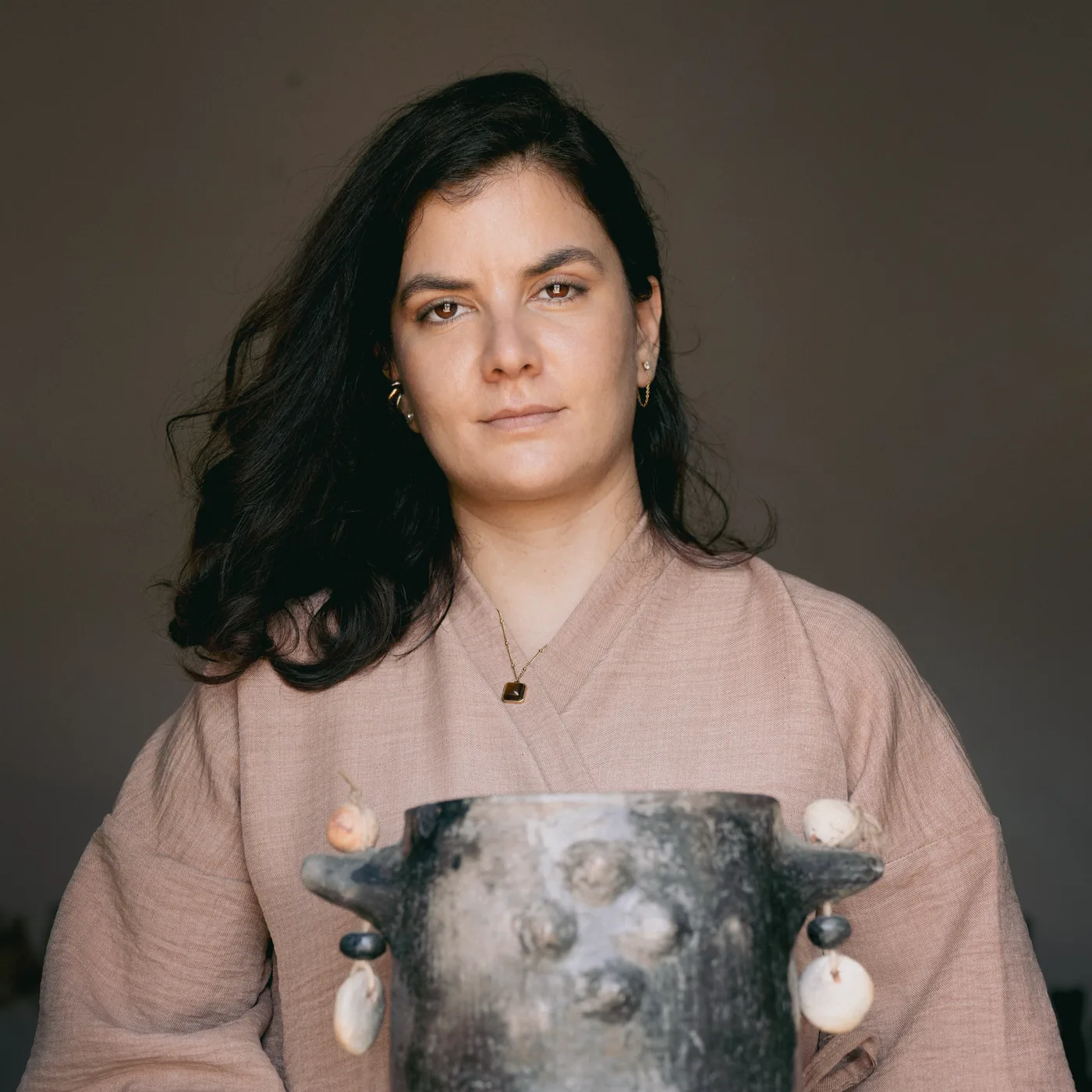 Portrait d'Amal Aissa, fondatrice d'Anaspika, tenant une pièce en poterie de Sejnane