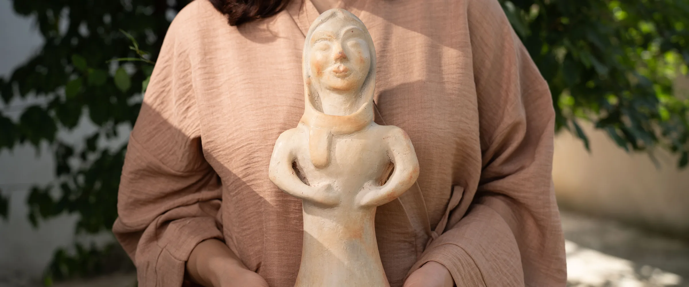 Amal Aissa tenant une statuette en poterie de Sejnane, contact professionnel Anaspika