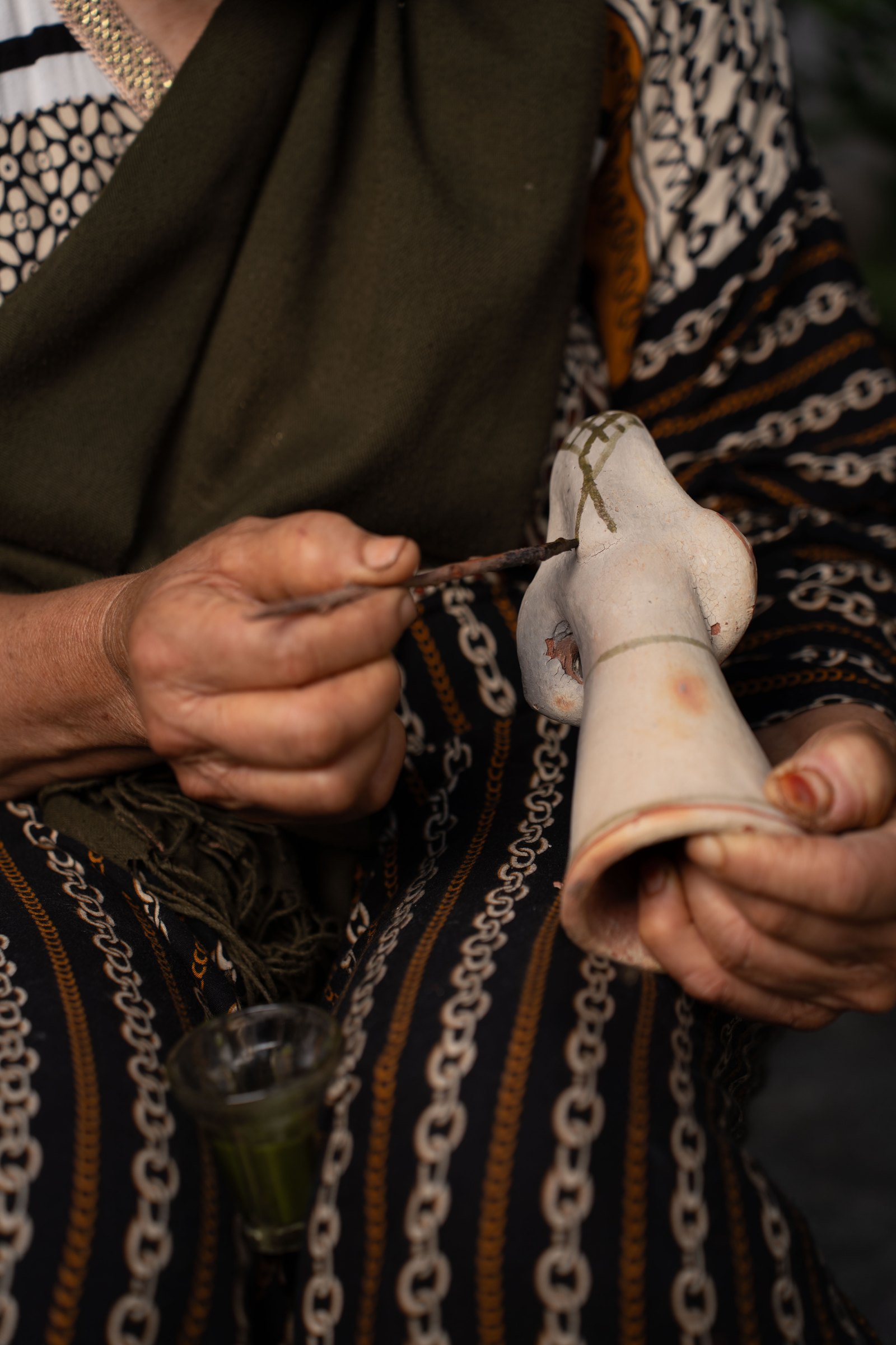 Application de motifs berbères au pigment de lentisque sur une poterie de Sejnane