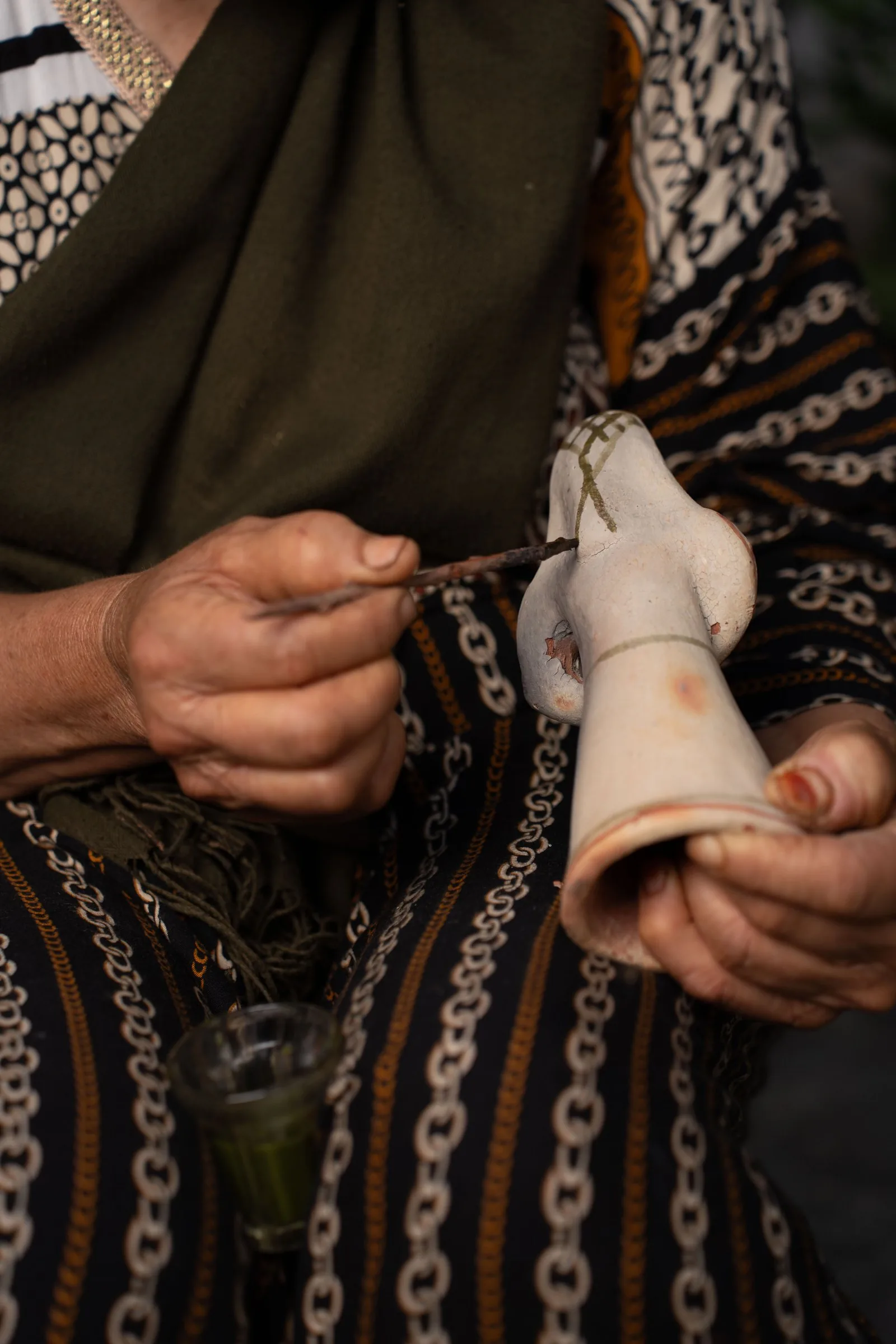 Application de motifs berbères au pigment de lentisque sur une poterie de Sejnane