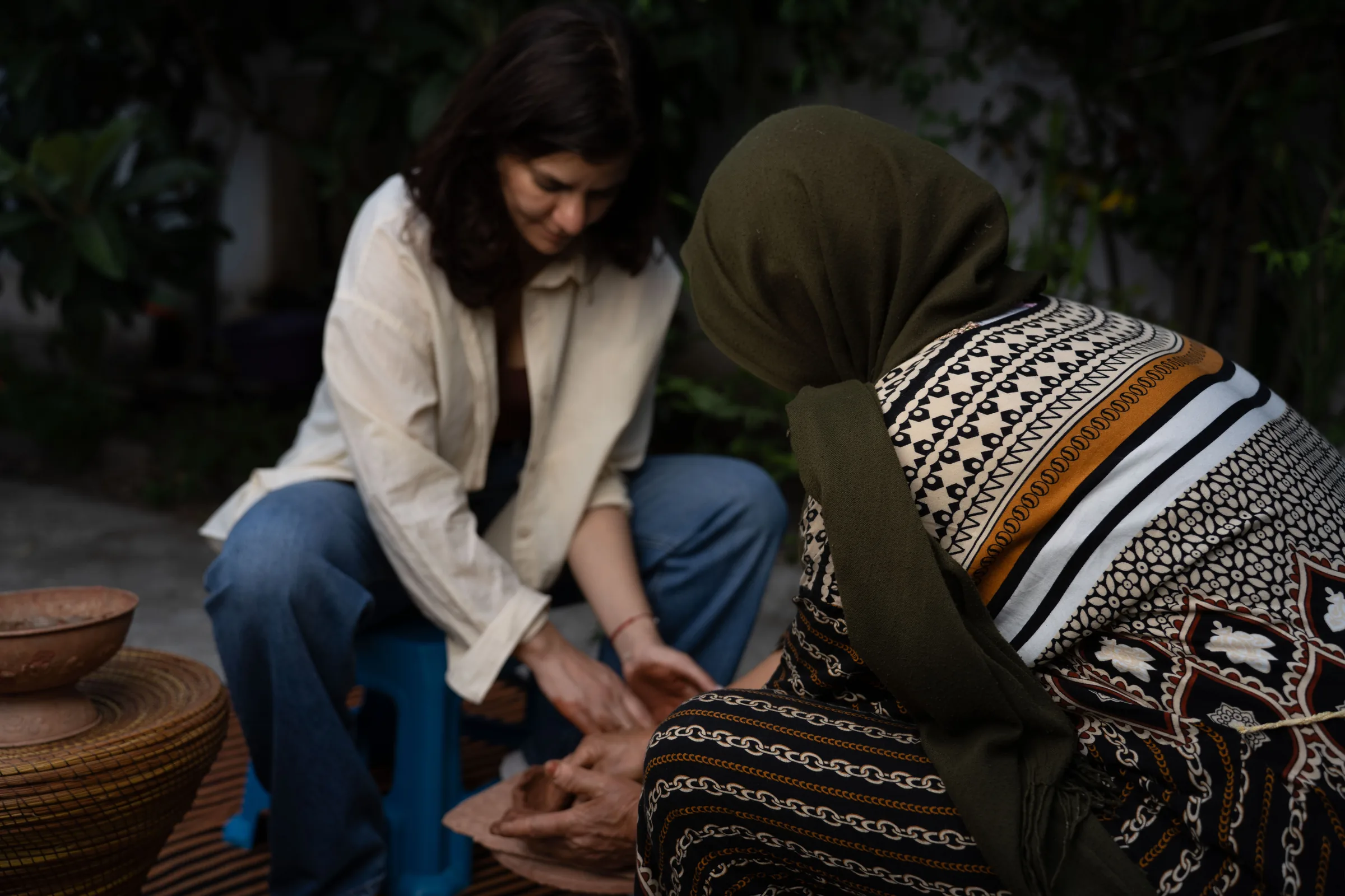 Amal Aissa et une artisane de Sejnane façonnant l'argile à la main, assises face à face